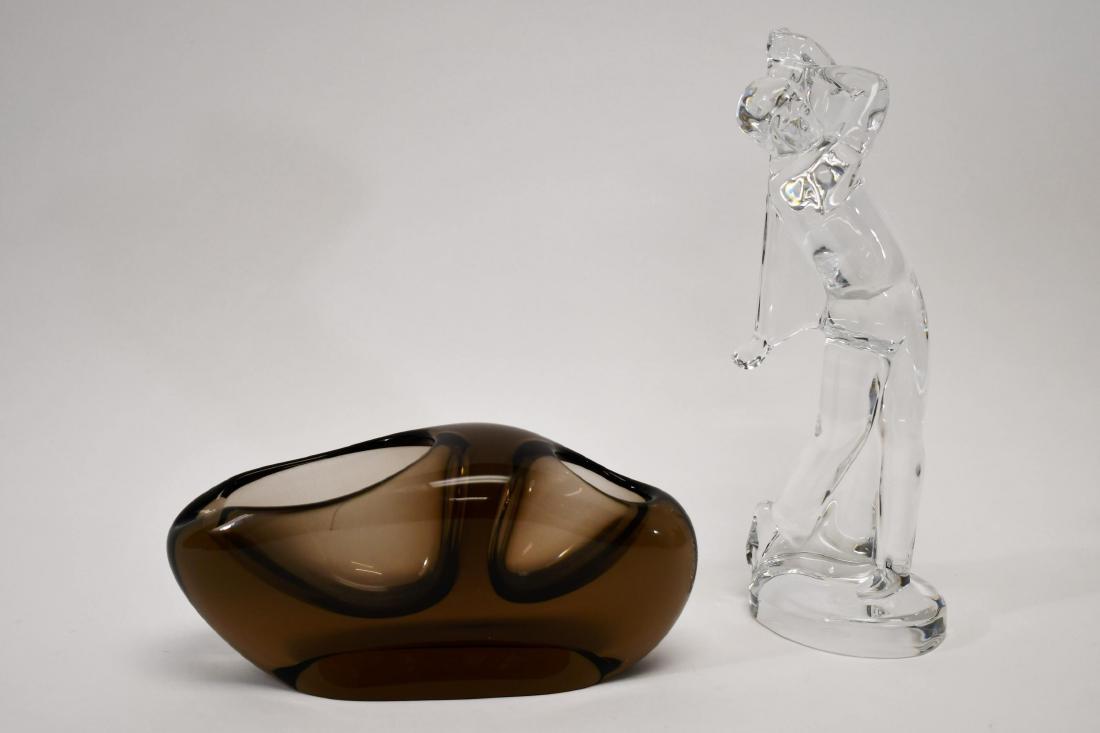 (2) pcs Holmegaard Cigar Ashtray & Baccarat Golfer: (2) Piece glass group includes; (1) Danish modern smoked glass Holmegaard cigar ashtray, attr. to Per Lutken. Excellent condition, minor wear. Measures 8.5" x 3" x 3.75". (1) Clear glass Baccarat Golf