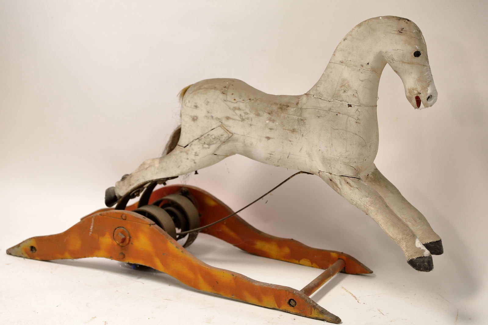 19c Primitive Rocking Horse Mounted Forged Spring: 19th Century primitive carved wood rocking horse mounted on a hand forged steel spring. Good condition. Loss of mane, tail and saddle. Measures 60" x 15" x 33".
