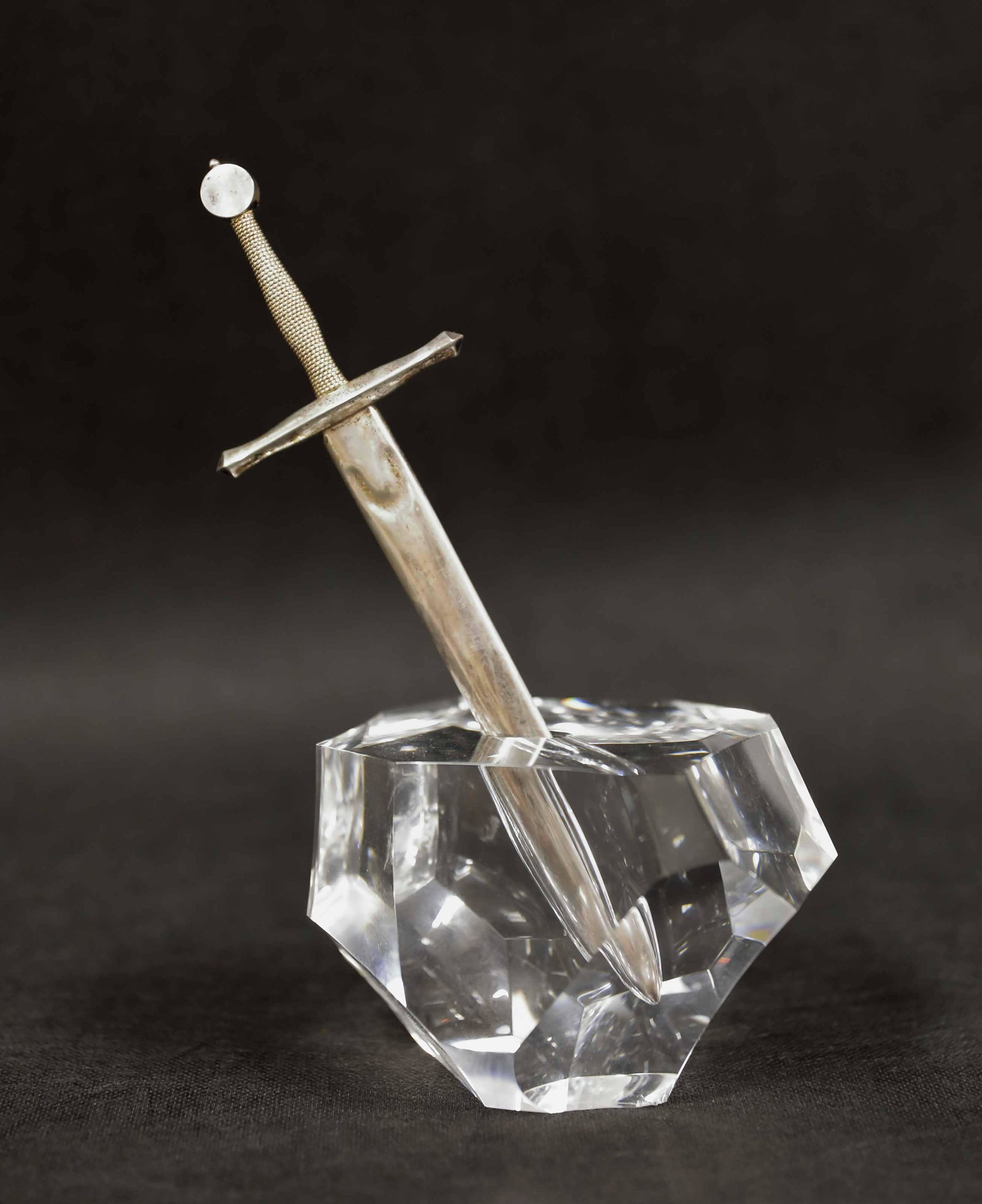 Steuben Glass & Sterling Excalibur Sword Desk Tool: Steuben art glass "rock" with a heavy sterling silver sword. Excalibur sword in the form of an executive desk top letter opener. Very good condition, chip on one corner at the base with an accompanyin