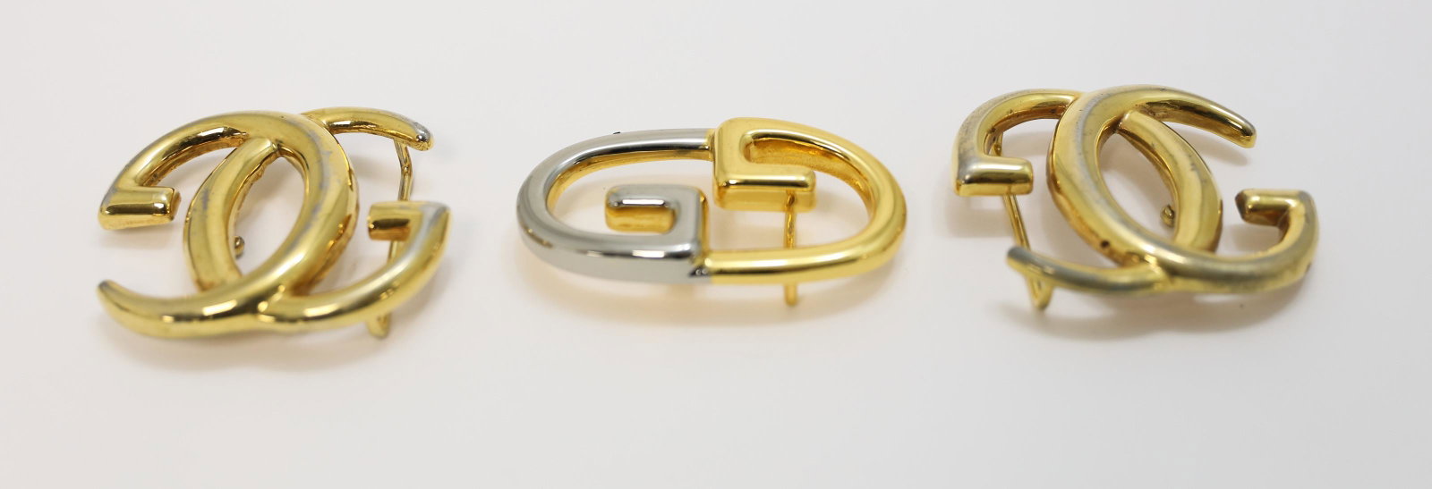 (3) Gucci, Italy Gold & Silver Belt Buckles: (3) Gucci, Italy (2) Gold finish with 1.75" bale, some wear. (1) Gold and silver finish belt buckle with 1.25" bale. Excellent used condition.