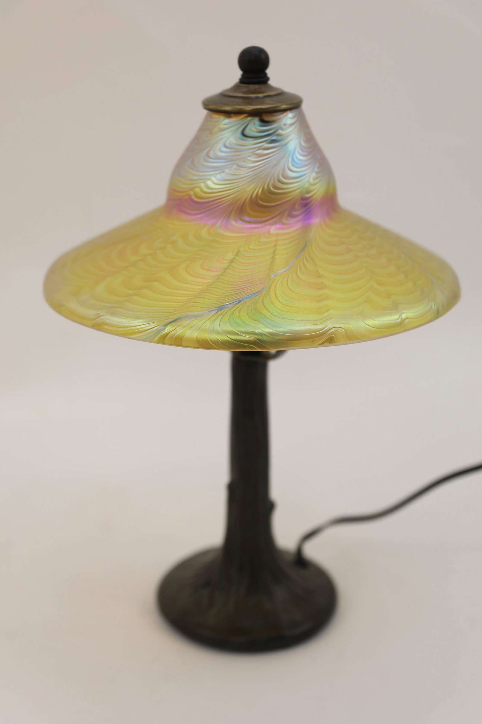 Iridescent Art Glass Mushroom Lamp w Tree Base: Robert Tsai designed Iridescent Art Glass mushroom form lamp with tree base. Tiffany style ribbed iridescent lamp shade with patinated metal base. Excellent condition. Measures 10" dia x 14.5".