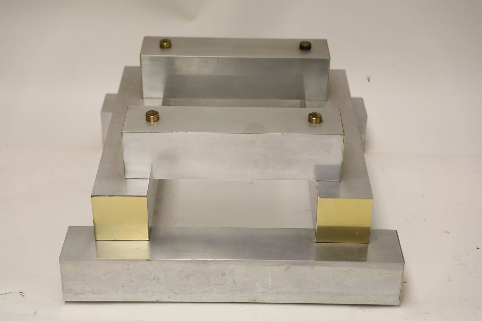 Paul Evans Aluminum Geometric Stack Coffee Table: Paul Evans style aluminum geometric stack coffee table. Rectangular beams with brass end caps, includes glass top. Excellent condition with patina, needs polished. Measures 29.5" x 28.5" x 14.5". Glas