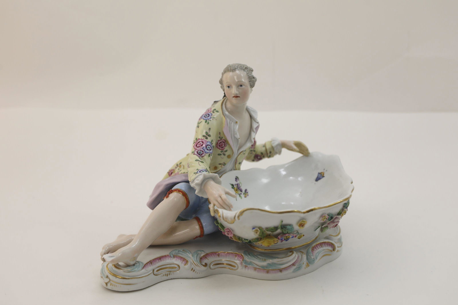 19c Meissen Candy Dish w Male Reclining by a Basin: 19c Meissen Candy Dish in the form of a well dressed young man reclining by a floral decorated basin. Good condition, shows old repair at hand, minor flower losses, damage to foot. See photos. Measure