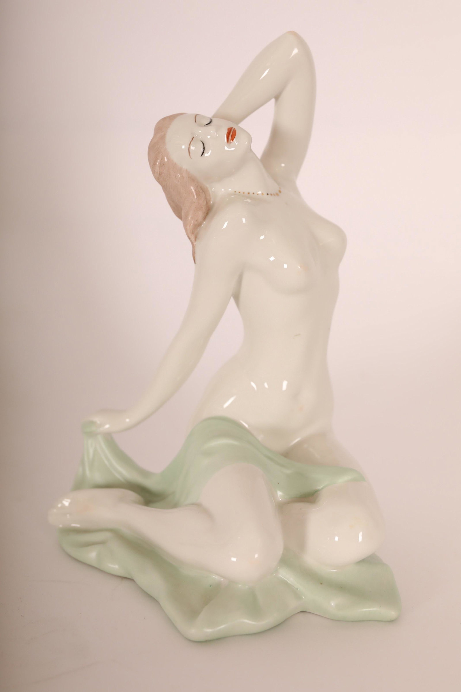 Aquincum Hungary Handpainted Porcelain Nude Female: Aquincum Hungary hand painted and glazed porcelain statue stretching while sitting on her knees. Base stamped "Hungary Aquincum Hand Painted" with seal. Excellent condition. Measures 6"dia x 9.5".