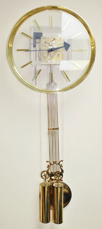Howard Miller Acrylic and Brass Pendulum Clock: Howard Miller Lucite and Brass Pendulum Clock. Perfect working condition. Measurements: 15 1/4" x 42 1/2" x 6" Year/Era: Mid-Century Artist: Howard Miller