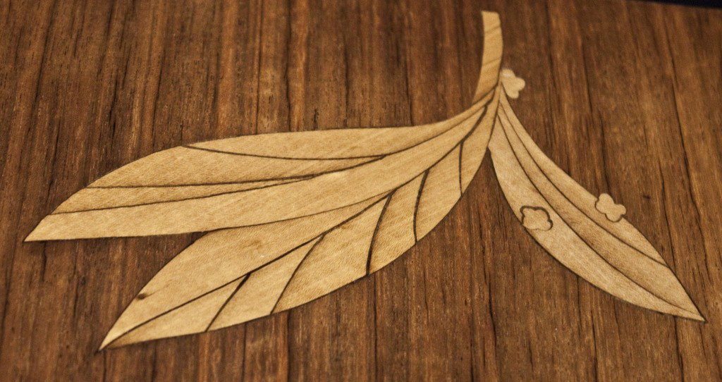 Charak Modern Inlayed Tiered Coffee Table: Multi Panel Inlayed Tiered Coffee Table. Inlayed With Butterfly, Pipe, Leaves, And Grape Bunch Designs. Attributed To Early Tommi Parzinger. Made By Charak Modern. Measurements: 50" x 20" x 18" Artist