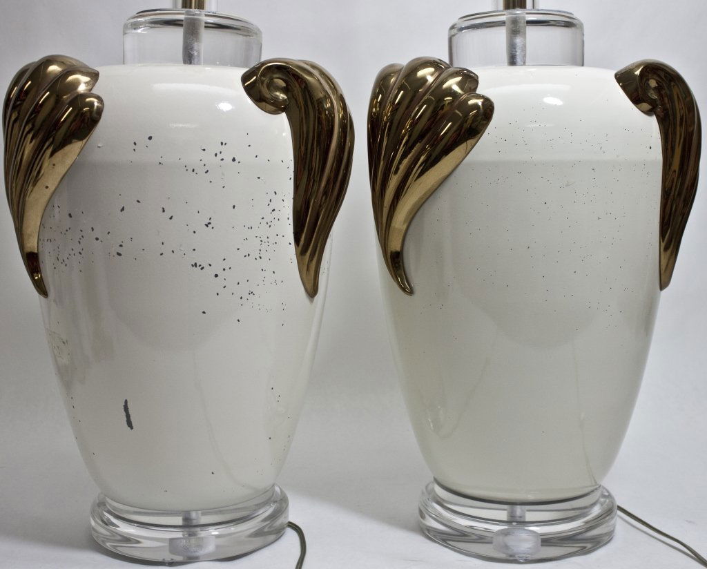 (2) Cream Colored Table Lamps w/ Brass & Lucite: Pair (2) of cream colored painted metal table lamps adorned with polished brass shell forms, Lucite finials and collars at bases and necks. Shows wear, as pictured. Measurements: 10"d x 19" (to harp)