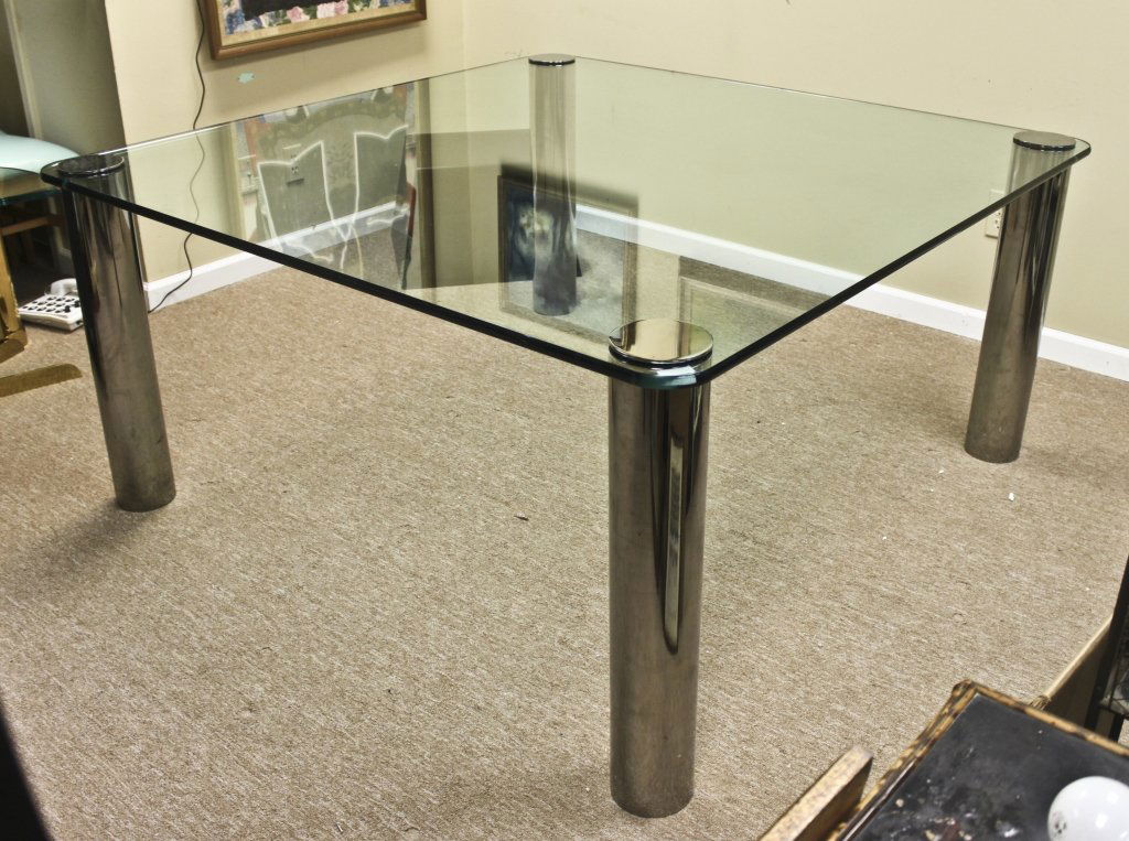 Springer Glass Dining Table: Large, square Karl Spring dining table. 3/4" glass top on chrome legs assembled with through-bolts and chrome caps. Legs adjust for leveling purposes. Very formidable and very heavy (250-300lbs). Show