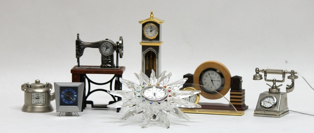 (8) Miniature Clocks: Lot of eight miniature decorative clocks: a Platinum grandfather clock and two Platinum novelty clocks, one shaped like a sewing machine the other like a tea pot, a Skagen novelty clock shaped like an