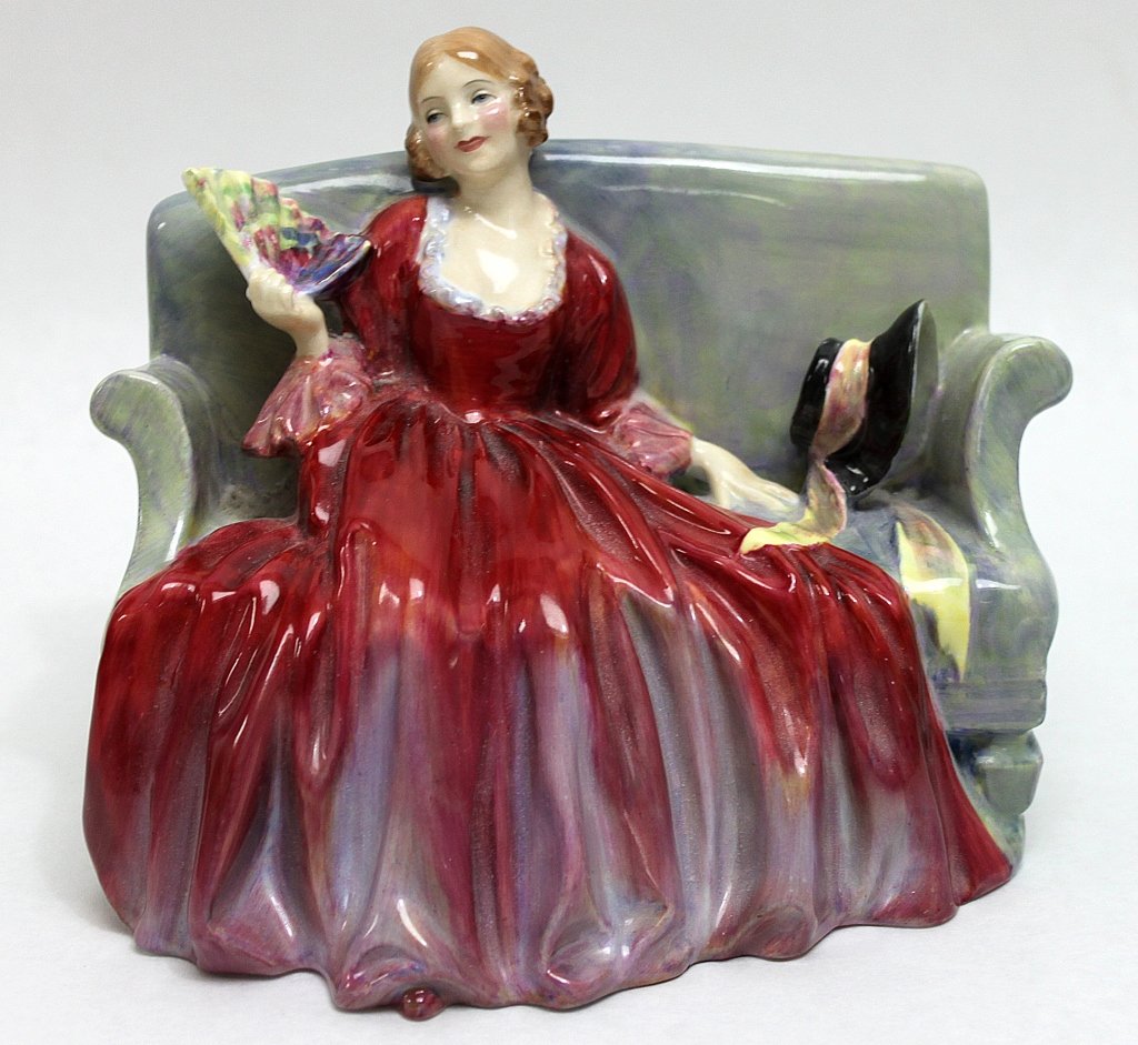 Royal Doultan Porcelain Figurine Sweet and Twenty": Royal Doultan porcelain figurine Sweet and Twenty" of a young woman seated in a red dress fanning herself, with her hat sitting beside her." Measurements: 7.5 x 4.5" x 5.75"" Artist: Royal Doultan Sty