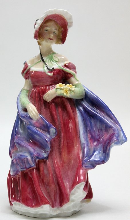 Royal Doultan Porcelain Figurine Lady April"": Royal Doultan porcelain figurine Lady April" of a woman in a red dress with a purple and red cloak and corsage of yellow flowers." Measurements: 4.5 x 3" x 7"" Artist: Royal Doultan Style: MidC Modern