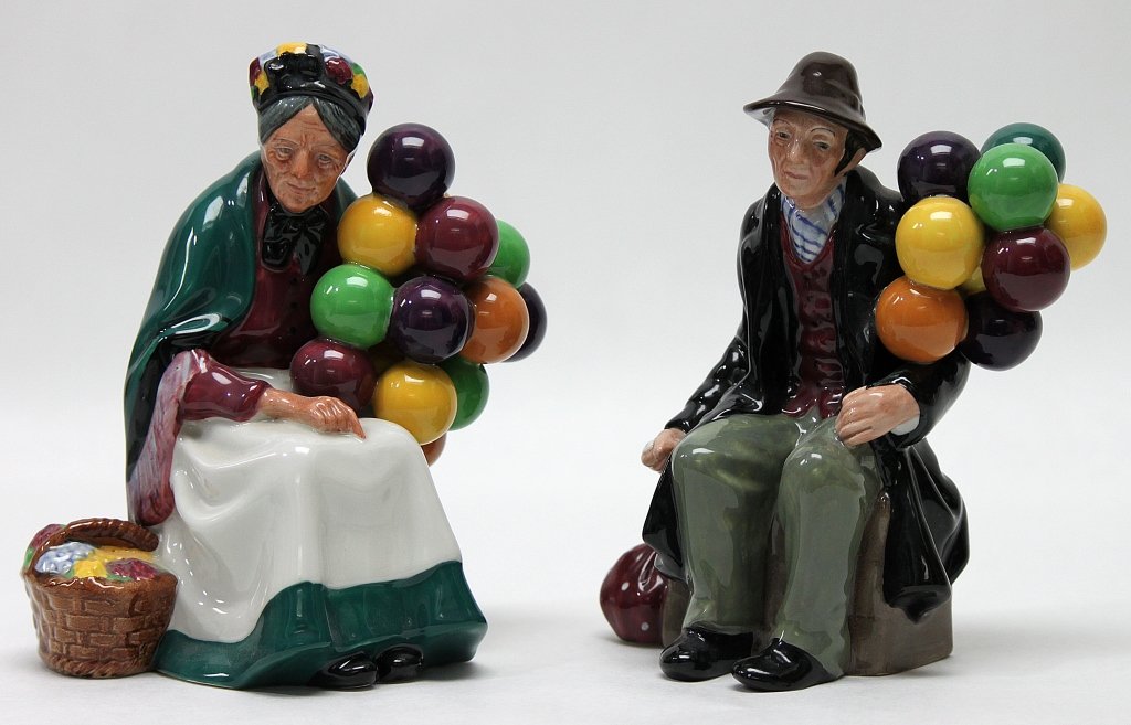 (2) Royal Doulton Porcelain Balloon Figurines: Two Royal Doulton porcelain balloon figurines. Both are in excellent condition and stamped on the bottom. The Balloon Man" measures 5" x 3.25" x 7", and "The Old Balloon Seller" measures 7" x 4" x 7".