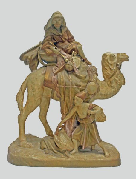 Amphora Royal Dux Arab w/ Camel & Slave Boy: Amphora Royal Dux figural group of an Arab on a camel tended by a slave Boy. Large and finally detail piece with an excellent original finish. Austria hallmark. Measurements: 20" x 10" x 24.75" Artist