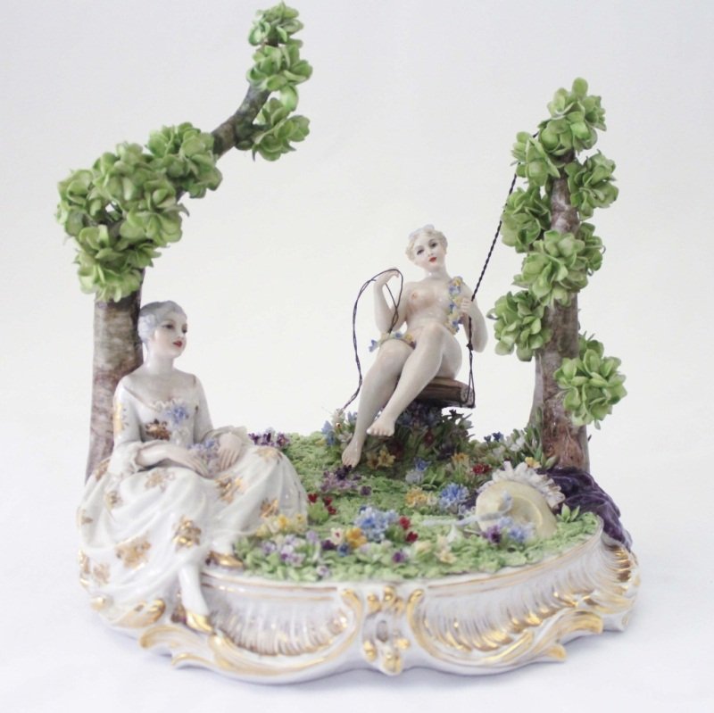 Fabris Italian Garden Scene: Italian porcelain garden scene featuring two girls in a garden, one of them on a swing .The string is disconnected on one side, and there is minor damage in the foliage. There is no significant damage