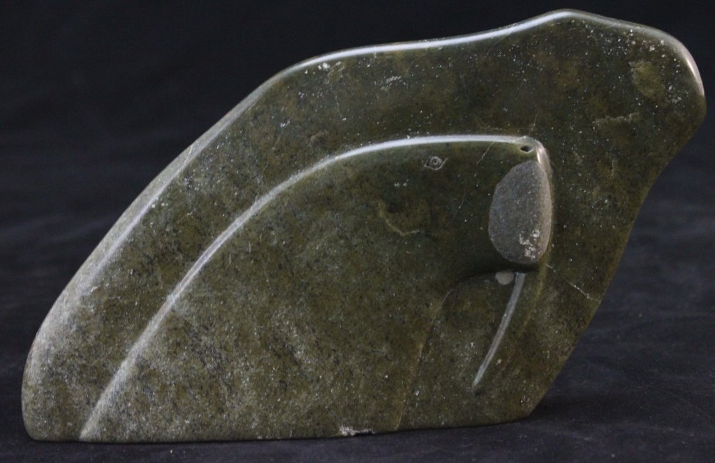 Inuit Serpentine Stone Carving of Walrus: Inuit serpentine carving of a walrus. Incised with the artists mark and 1975 on the bottom. Marked Canada Eskimo Art. Slight chip on edge of bottom. Measurements: 8" x 1.5" x 4.75" Period: 20th Centur
