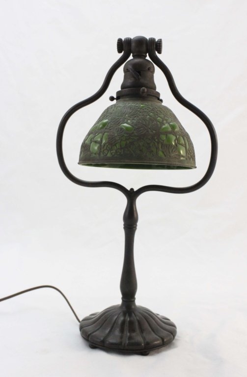 Tiffany Studios New York Harp Desk Lamp: Tiffany studios New York harp desk lamp in the "grapevine" pattern. Entire piece is beautifully patination with browns and greens. The green glass is blown through the grapevine pattern on the lamp sh