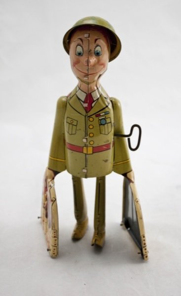 G.I. Joe & The K-9 Pups Tin Litho Wind-Up: G.I. Joe & The K-9 Pups Tin Litho Wind-Up Toy. Wind-up mechanism in working condition. Measurements: 3.5" x 3.5" x 9" Period: 1940's Artist: Unique Art