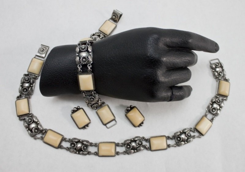 Sterling & Ivory Jewelry Set By N.E. From: Sterling silver and ivory matching necklace, bracelet, and ear clips by designer Niels Erik From (N.E. From) Denmark. Necklace composed of 7 cabochon ivory plaques and 7 sterling floral plaques. Measu