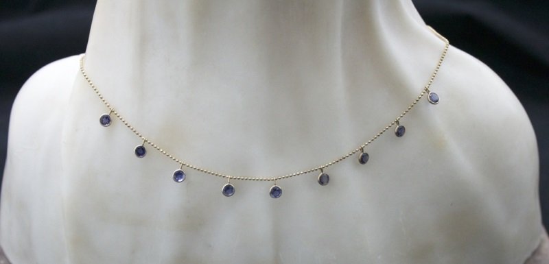 14K Gold Choker Necklace w/ Violet Blue Tanzanite: 14k gold beaded chain with 9 round violet blue tanzanite fixed drop charms, marked 14k- measures 14" Aprox. size of stones 5.2mm. Dimensions: See Description Period: 1 dwt Artist: 14k