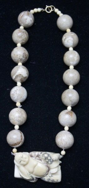 Buddha & Fossilized Coral Beaded Necklace: Buddha necklace and Buddha pendant, lot includes; Hand carved sleeping Buddha necklace with fossilized coral beads and small beads- Gold filled clasp. Artist signed on back of Buddha. Buddha measures