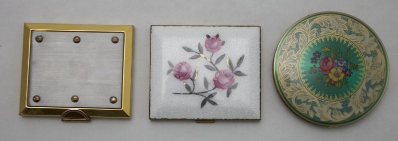 Lot Of 3 Compacts: Lot of 3 compacts, includes; Enameled compact with mirror, some residue from sticker on inside. Measures 3" x 2.5". Double mirror compact. Measures 3" x 2.5". Round compact, marked Stratton Made In En