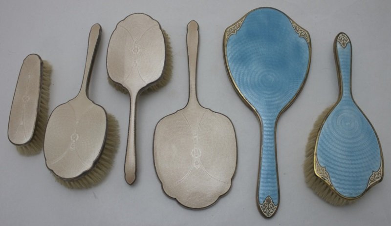 Engine Turned Sterling Dresser Brushes & Mirror: 3 English engine turned sterling silver and enamel dresser brushes with boar hair bristles and a mirror which is 10.5" x 4.25" x .5" Brass and enamel engine turned hand mirror which is 11.5" x 5" x .5