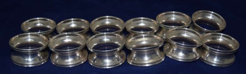 12 Sterling 900 Silver Napkin Rings: 12 Sterling napkin rings. Marked MA900. 6.80 OZT - Total Weight. 2" dia x 1" h