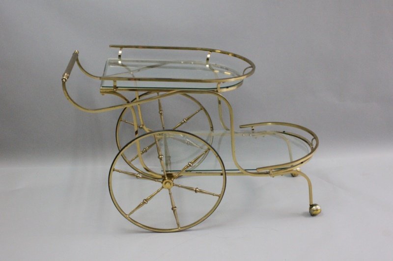 Regency 2-Tier Brass & Glass Tea or Bar Cart: Large brass, two tiered tea or bar cart with demilune glass shelves and gallery trim. Large spoke-back wheels and 2 front casters. Rolls very smoothly. Excellent condition. Measures 22" x 48" x 31".