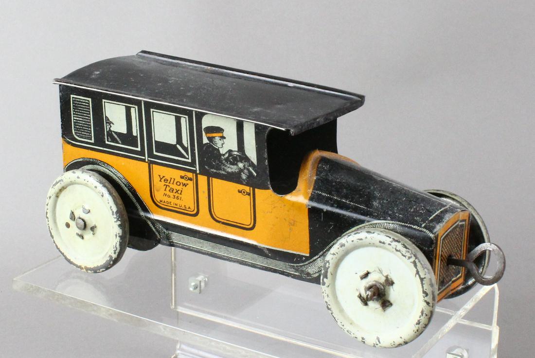 Mohawk Toys Tin Yellow Taxi Cab Wind Up: Early 1919 Mohawk Yellow Taxi cab with the front center wind up. Great period passenger litho.