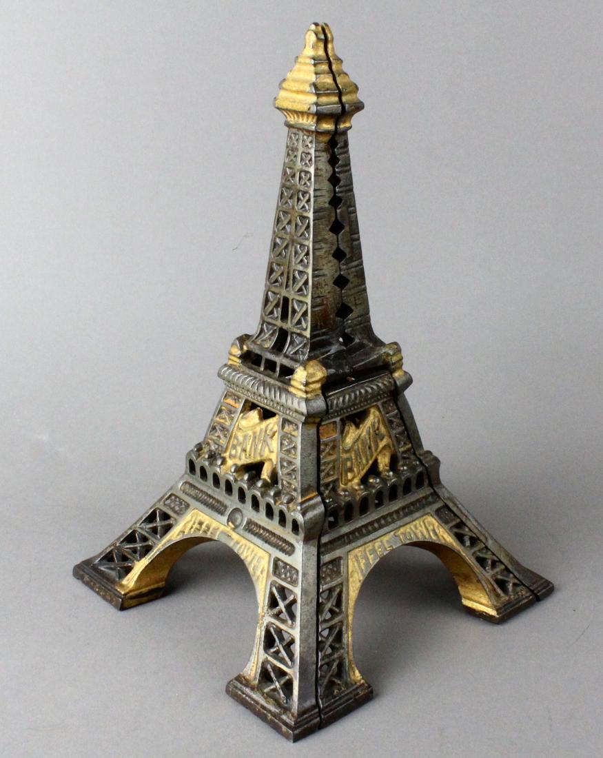 Eiffel Tower Still Bank: Eiffel Tower Bank. Cast iron with japanned finish, coin slot at center of tower. Eiffel Paris on all four sides. 9 inches tall excellent original paint. Sydenham & McOustra England - Circa 1908.