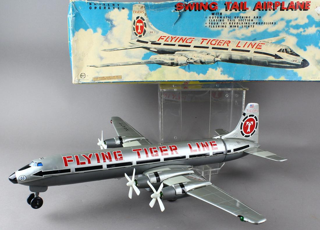 Marx Flying Tiger Line Airplane in Box Working: Excellent working swing tail airplane made in Japan for Marx. Plane taxis down runway with flashing lights and 4 Prop action starts. Then the tail section opens revealing cargo. It closes back up and 