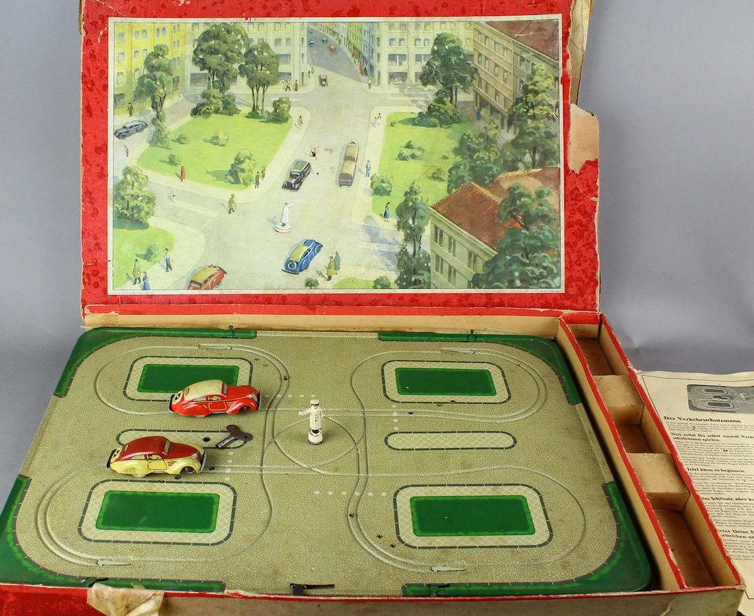 Tippco German TIn Traffic Set in Box & Cars: 1930s Tippco Tin cars and police track set-with traffic policeman. Fine condition Pre-war wind up cars and tin track set. Box graphics are bright, box has broken side flaps and some small holes. Cars 