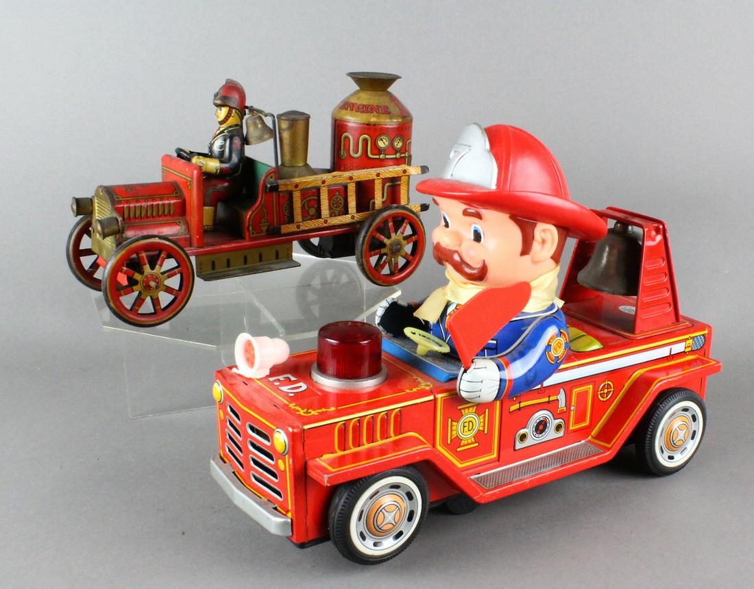 2 Japan Tin Litho Fire Engines: One Japan tin fire engine in the old fashioned style of 1910 evocative of the German tin toys like Distler, the other fire engine with the more Cartoon character fire chief at the whell. Excellent ove