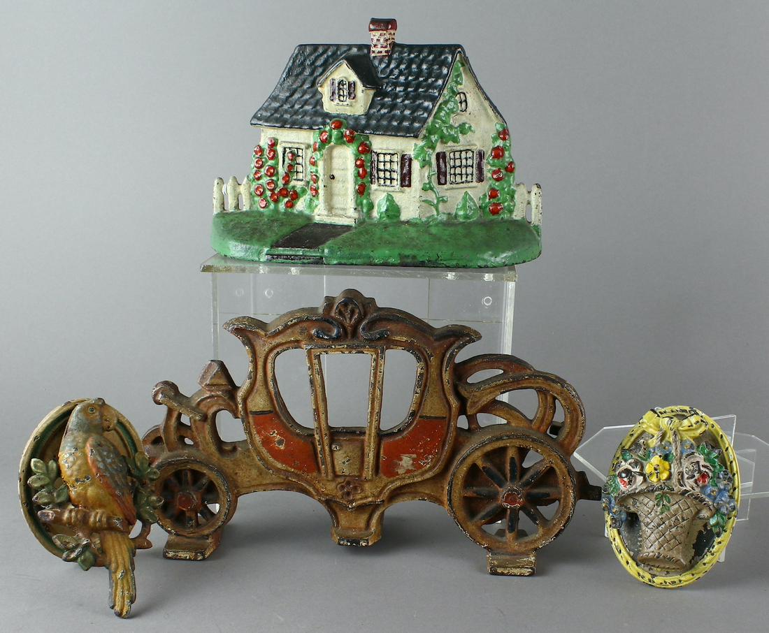 Cast Iron Door Knockers & Door Stops: Cast Iron Cottage Door Stop possibly by National Foundry, pair of Hubley Floral & Parrot door Knockers and Cinderella carriage door stop. Cottage is 5 3/4 tall x 7 1/2 inches wide.