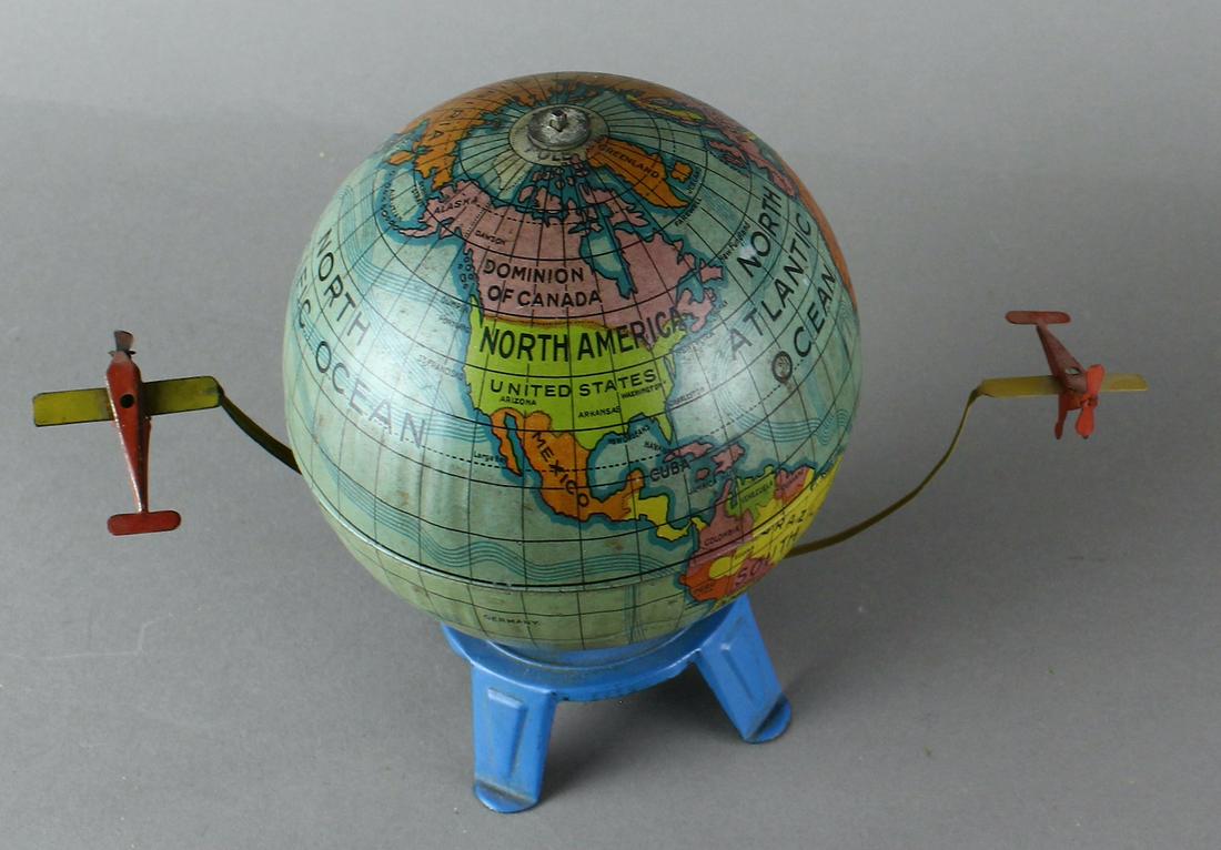 German Tin Pre-War Airplanes Circling Globe: German Tin Airplanes Circling Globe. Scarce working wind up, the earth turns and the two tin airplanes circle the globe. Very detailed toy. One airplane has very stable epoxy connecting it to the revo