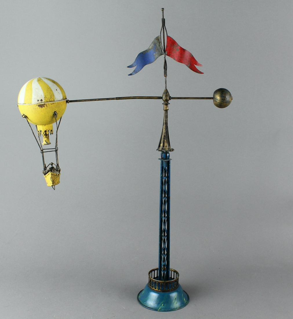 French Tin Hot Air Balloon Revolving Wind Up: c. 1900-1910 France Tin Hot Air Balloon Revolving Wind Up. Very Rare toy turns around tall rod and flags and is working. See the only other example sold by Ladenburger Spielzeugauktion GmbH on LiveAuc