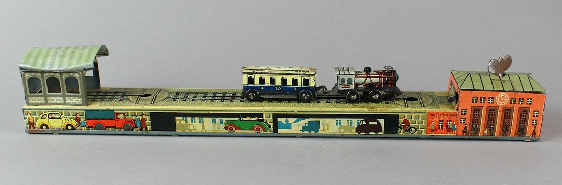 Arnold German Tin Turn Around Train on Platform: Arnold German Tin Turn Around Train on Platform. Steam engine and passenger car, loco able to turn around on track and pull passenger car then release it at end. 15 1/4 inches Works great.