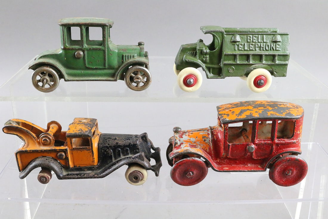Four Hubley Cast Iron Cars & Trucks: Four Hubley Cast Iron Cars & Trucks 4 to 5 inches. Wrecker missing rubber rear tires, Sedan with repaint. Bell Truck probable repaint.