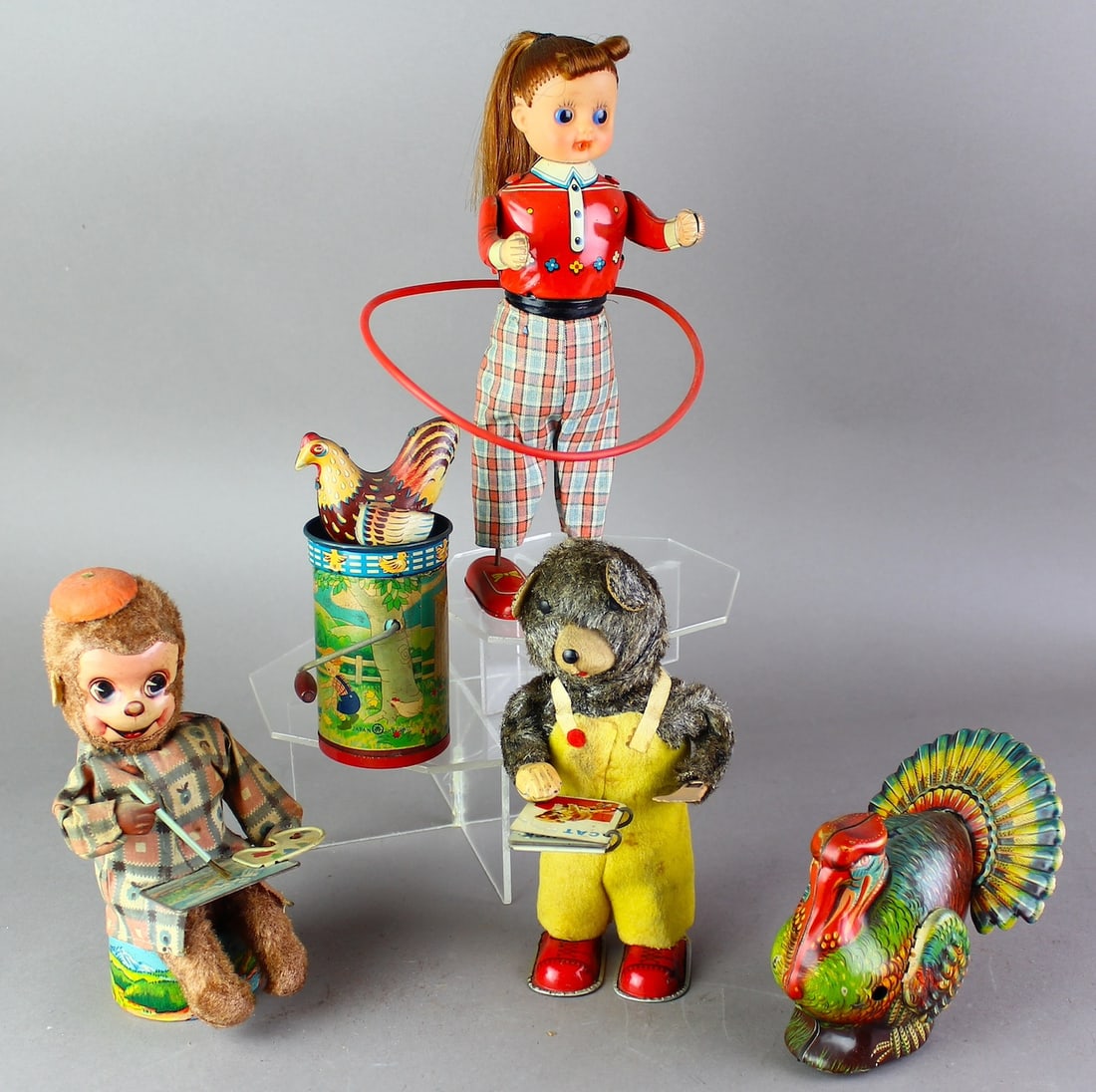 5 Japan Tin Wind Ups & Pre-War Toys: Japan wind up Bear reading book, turkey, hula-hoop girl, monkey artist, and pre-war crank chicken. Toys were all working at time of testing.