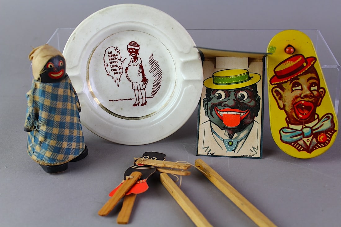 German & Japan Black Memorabilia: German & Japan Black Memorabilia. Graphic stereotype images of the period. Dish china, Mammy Doll, Noise Maker, Japan trapeze toy. German fold out - tongue comes out. Bright graphics.