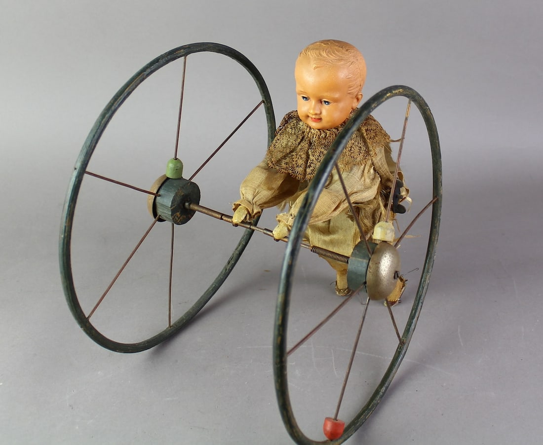 1900s Parambulator Child Doll Rolling Wheel Toy W/U: 1900s Parambulator Child Doll Rolling Wheel Wind Up Bell Toy. Wheel about 10 inches in diameter. Wind up is working.
