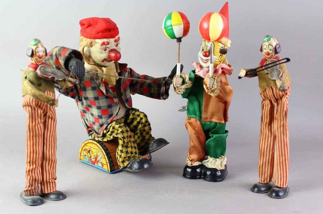 4 Japan Tin Wind Up Clowns TPS & Others: Clown Spinning Beachg Balls, 2 TPS Clown on Stilts wind ups, Battery operated clown (playing violin missing). One TPS wind up not working, Ball spinning clown works perfectly, Battery Op not tested.