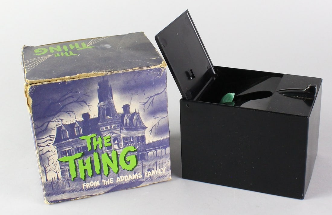The Thing Addams Family Hand Grabs Coin Bank in Box: The Thing Addams Family Bank. Hand Grabs Coin Bank, in the original Box. Update: motor runs and coin activates properly, hand is not grabbing coin.