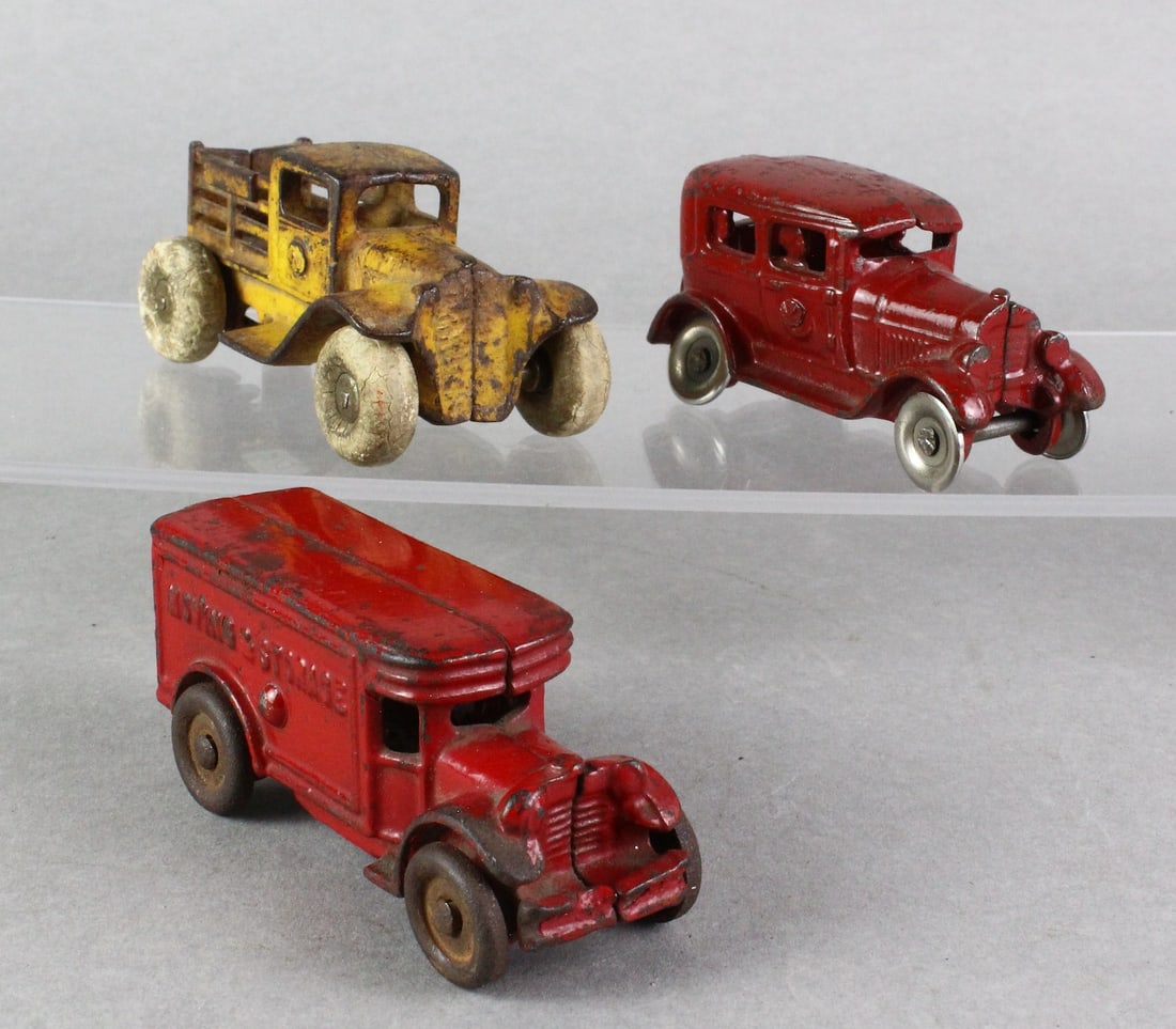 Cast Iron Sedan & Trucks: Sedan with driver, Moving & Storage Truck and Kilgore Stake Truck, 4 inches long.