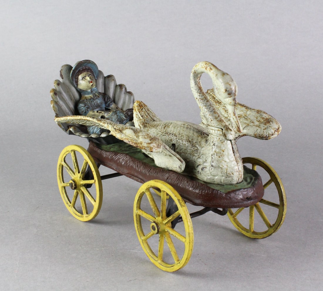 J.E. Stevens Swan Chariot Cast Iron Pull Toy: J.E. Stevens Swan Chariot Cast Iron Pull Toy. Huge swan's wings flap as it is pulled. Appears repainted, wooden noise box on bottom not making noise. 9 1/2 inches long.