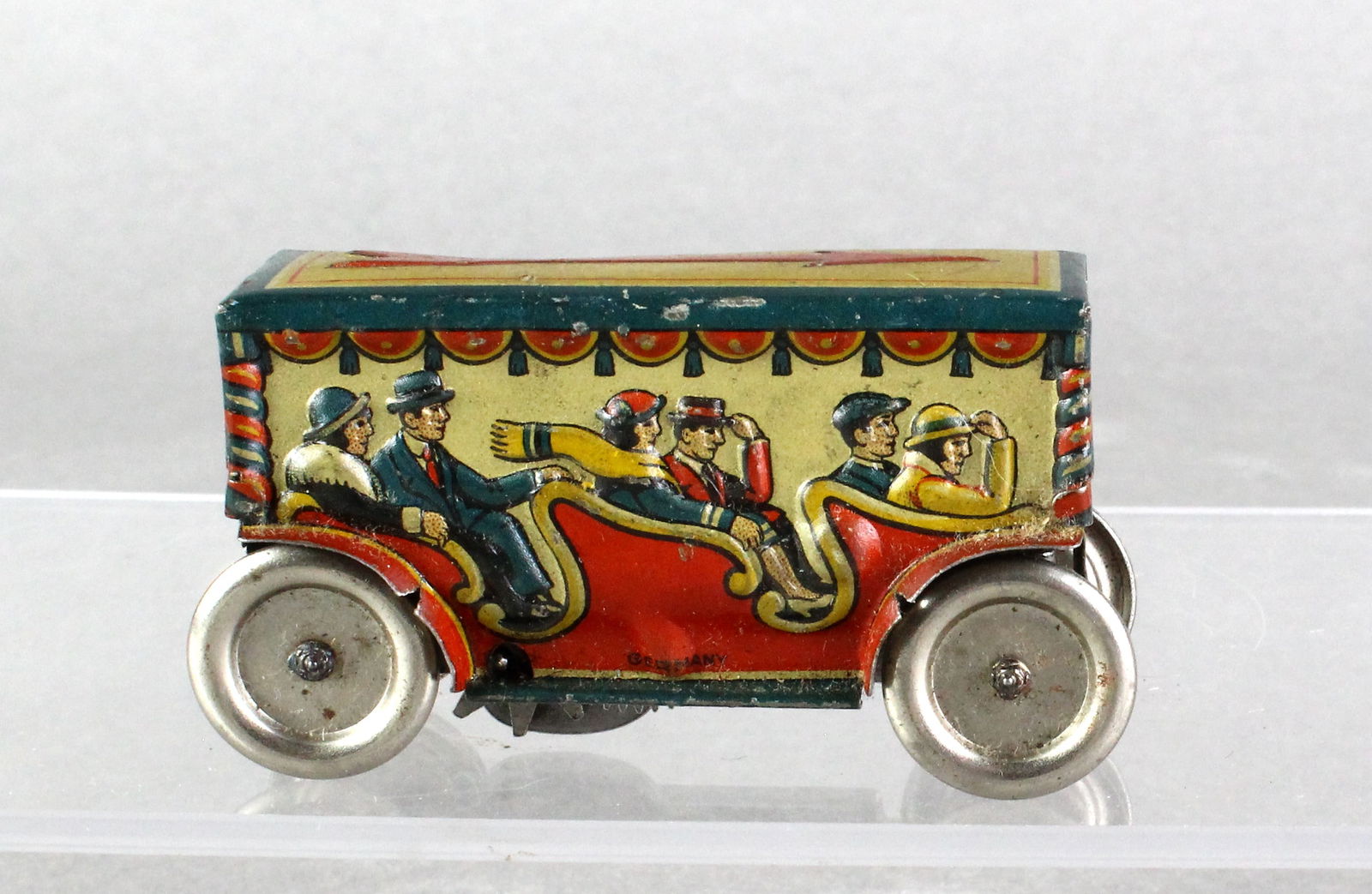 Wind Up German Tin Carnival Trolley Penny Toy: Wind Up German Tin Carnival Trolley with passenger litho. Nice working tin toy. Approx. 3 inches long.
