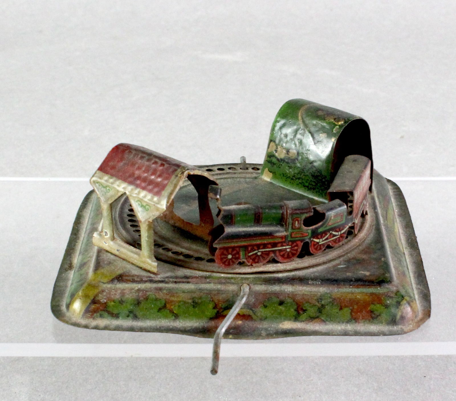GELY German Penny Toy Train Platform: German Penny Toy Train Platform. GELY, George Levy diminutive detailed tin litho wind train going through tunnels. Crank action, base illustrated with country scenes, 3 1/2 inches wide.
