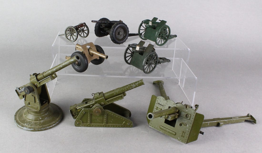 Britains Cannons, Artillery Guns England: Metal Bullock Gun Artillery Spring Loaded Gun, Long Range Gun and Field Shielded gun, all made in England. Britains wheeled cannons, smaller guns on shelf. 8 Total. Longest 11 inches.
