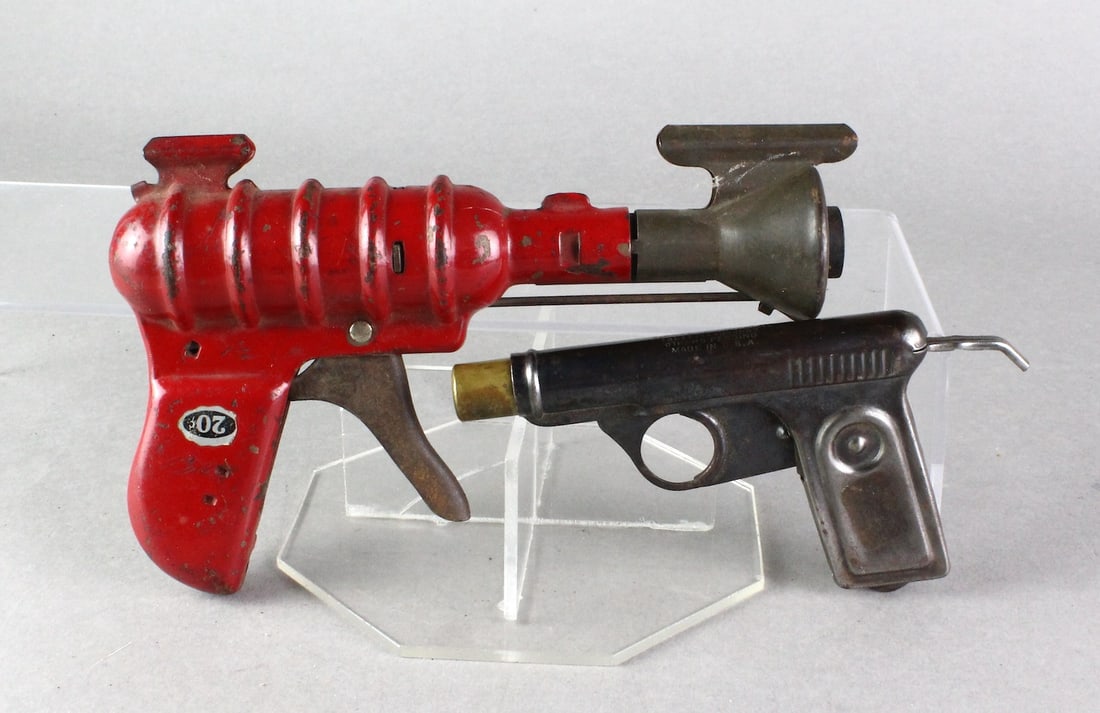Early Metal Space Ray Gun & Squirt Gun: Early Metal Space Ray Gun & Squirt Gun. Red gun with 20 cent price tag mark and metal water gun. Longest 8 inches.