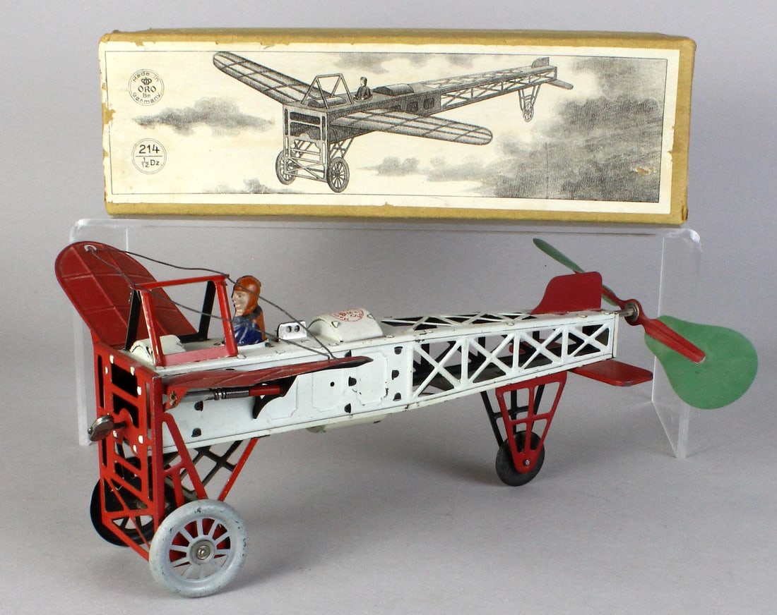 1909 Orobr Monoplane in Box Pristine: Orobr Early Aviation Airplane wind up tin toy in the original factory box. Seated pilot and working wind up propeller and 11 1/2 inches long. Beautiful engraving of the airplane in flight on the box. 